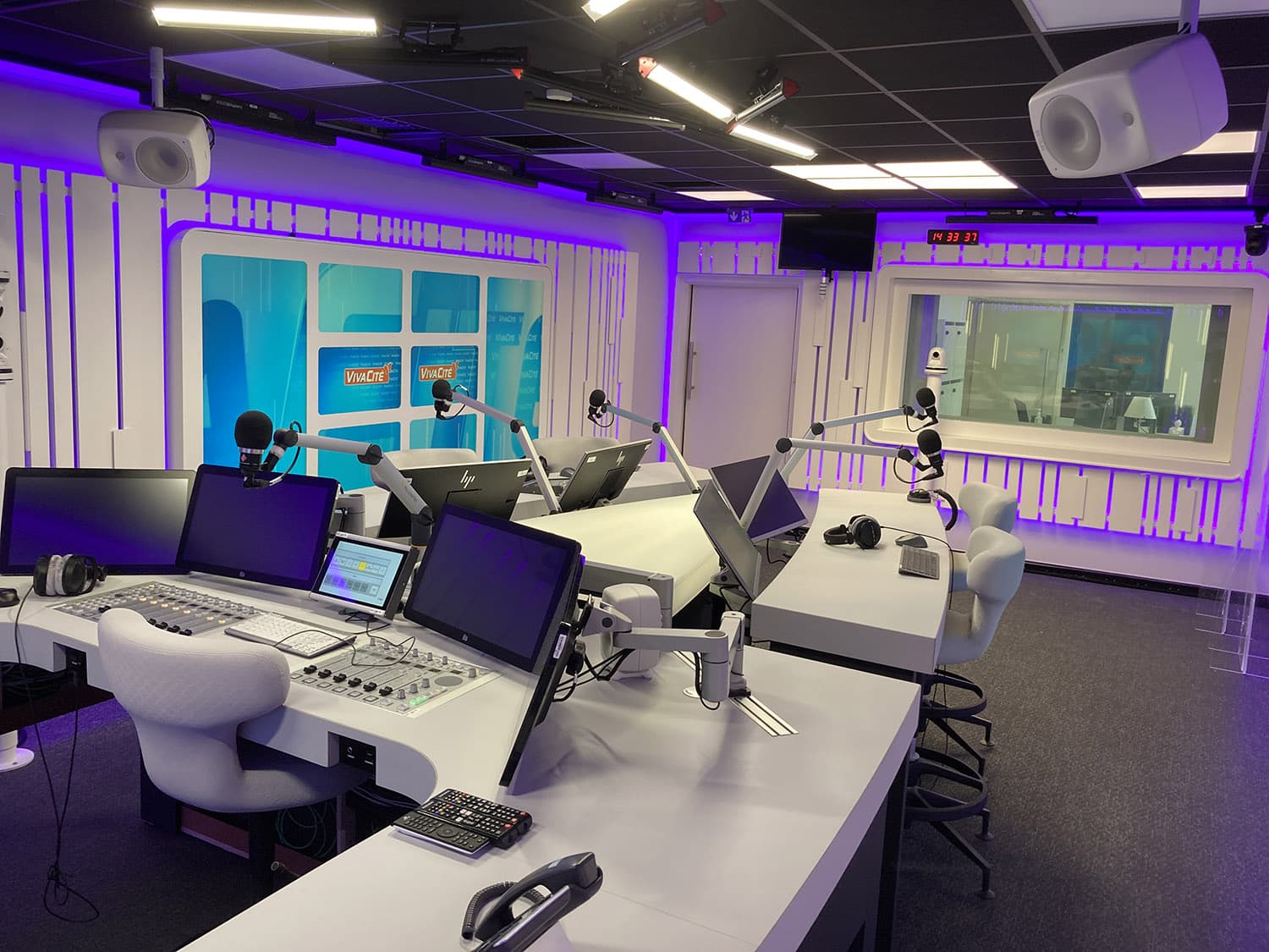 The on-air studio has visual contact with the adjacent production room.