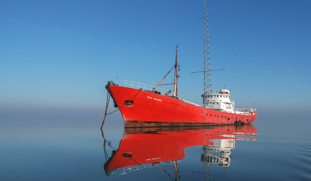 The M.V. Ross Revenge at anchor, bright red boat on a blue sea