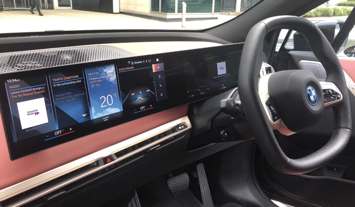A BMW car dashboard with radio information on the consoles