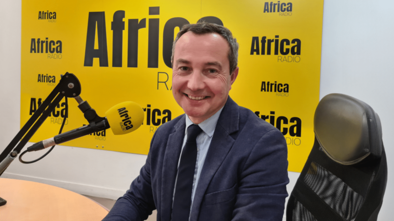 Jean-Baptiste Bancaud sits in front of a microphone at Africa Radio