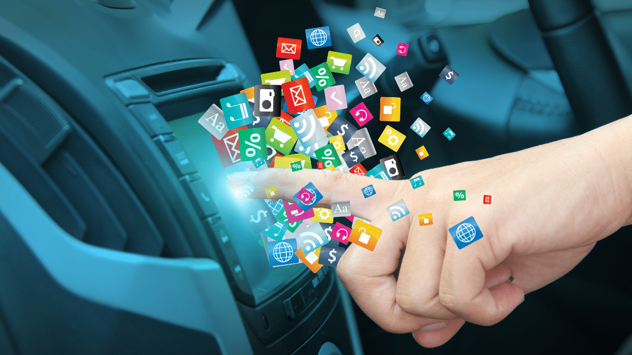 A finger touches a car touchscreen, releasing a variety of multicoloured icons